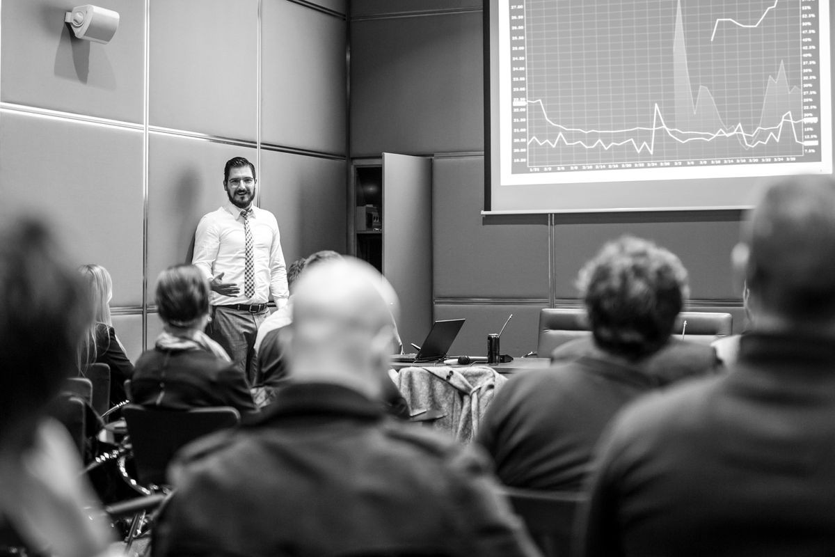 Public Speaker Giving a Talk at Business Meeting. Audience in the conference hall. Business and Entrepreneurship concept. Black and white image.